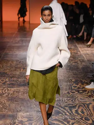 Imaan Hammam wears two layered turtlenecks and green suede midi skirt on the Bottega Veneta fall 2024 runway
