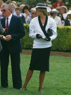 Princess Diana wearing a black and white hat, white sweater with black collar, black gloves, and black skirt on an official engagement in Melbourne, Australia