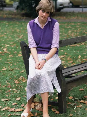 Princess Diana wearing purple vest over light purple button-down shirt and patterned midi skirt