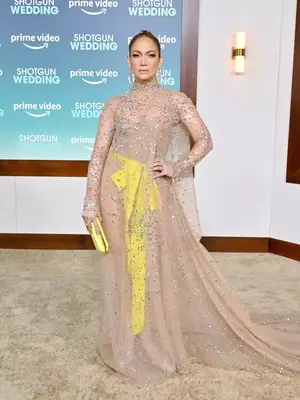Jennifer Lopez wears a sheer sparkly Valentino gown with yellow bow to the Shotgun Wedding premiere
