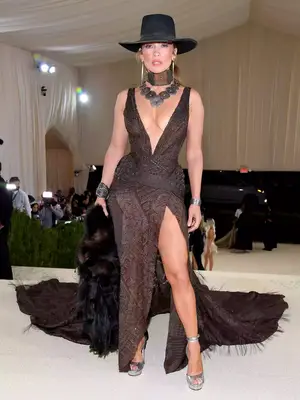Jennifer Lopez wears a Ralph Lauren gown with plunging neckline and a brimmed hat to the 2021 Met Gala