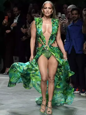 Jennifer Lopez walks the Versace runway in a jungle print gown with plunging neckline