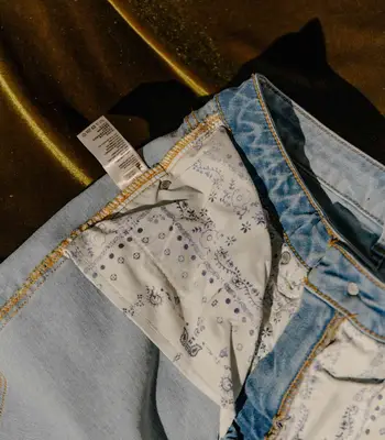 Close-up of inside-out light wash jeans with pockets and tags visible