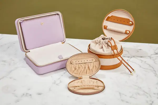 A photo of travel jewelry cases on a marble table