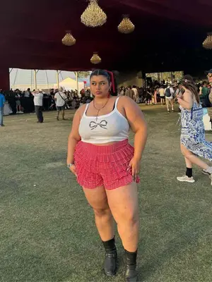 person wearing a bow tank top and red gingham shorts