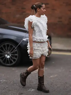 woman wearing a ruffled top and ruffled shorts with boots