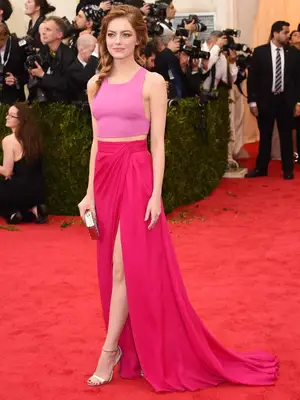Emma Stone wears a pink top and maxi skirt set and fishtail braid to the 2014 Met Gala