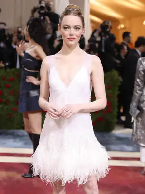 Emma Stone wears a white Louis Vuitton dress with feathered hem to the 2022 Met Gala