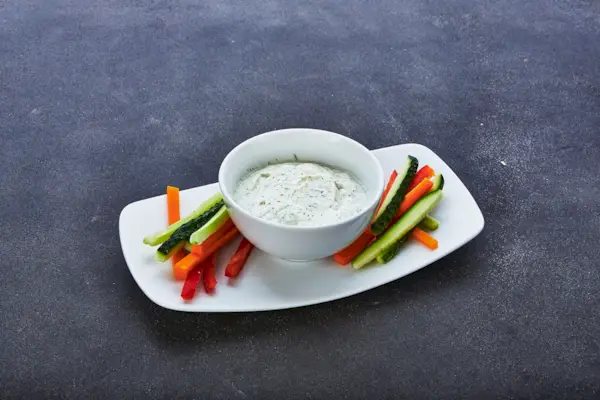 Assortimento di verdure e salsa con formaggio feta su sfondo di legno, primo piano