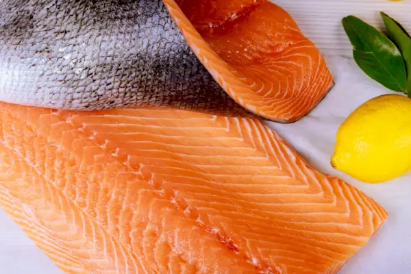 Vista en ángulo alto de pescado con limón en la mesa