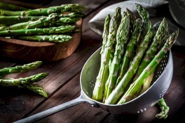 Fresh asparagus in an old metal colander