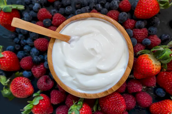 Greek yogurt in a glass jars with spoons,Healthy breakfast with Fresh greek yogurt, muesli and berries on background