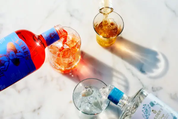 Several Cocktail or mocktail glasses with rose wine drink on blue