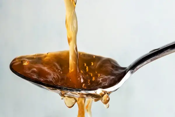 Mixed race woman drinking wine and using laptop