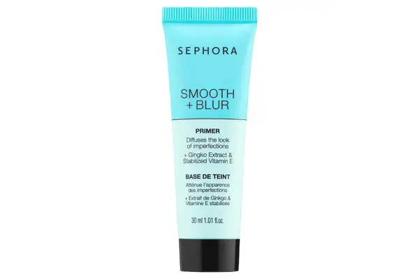 A person holding the Tatcha The Silk Canvas Protective Primer jar near their face