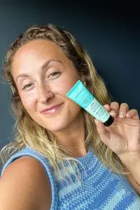 A person holding the SEPHORA COLLECTION Smooth + Blur Primer tube near their face