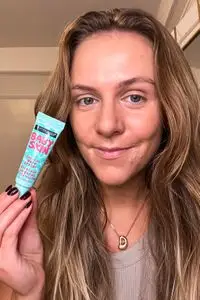 A person holding the Maybelline Baby Skin Instant Pore Eraser Primer tube near their face