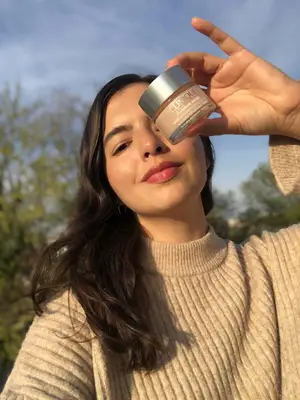 Young woman holding the Clinique Moisture Surge product