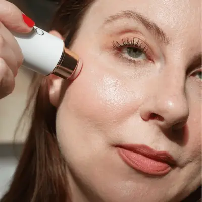 Woman swiping an Ogee Beauty face stick on her cheek