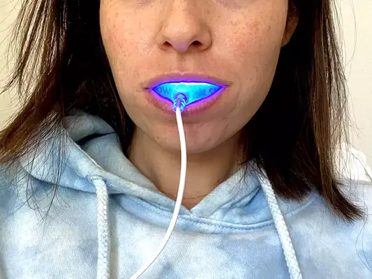 A person using the Snow Teeth Whitening LED Light