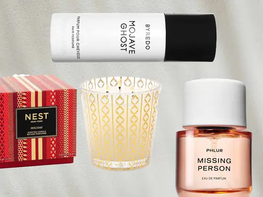 Nest Fragrances holiday candle, Byredo Mojave Ghost hair perfume, and Phlur Missing Person fragrance
