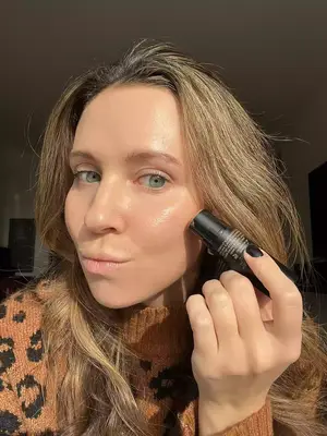 A person applying the NudeStix Nudies Matte Bronzer Stick