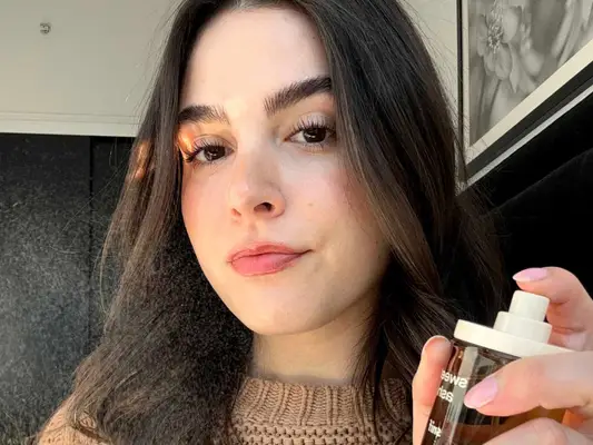 Woman sprays Snif Sweet Ash fragrance in the air