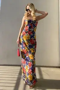 A woman wearing the Rumored Vintage Florals Slip Maxi Dress from Nuuly