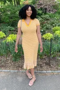 A woman wearing a dress from a Rent the Runway delivery bag