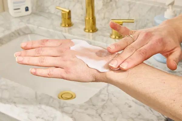 Person rubs CeraVe Daily Moisturizing Lotion into the back of their hand