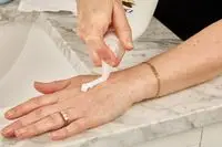 a tester pumps Dove Body Love Glowing Care Body Lotion onto their hand
