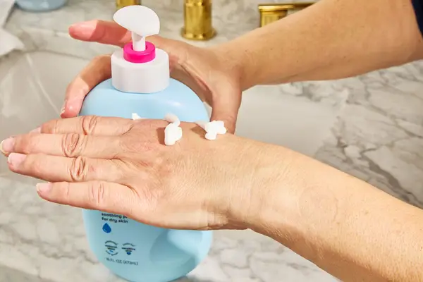 person dispensing eos Shea Better 24H Moisture Body Lotion to back of hand