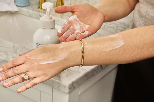 person applying Saltair Body Lotion to their arm 