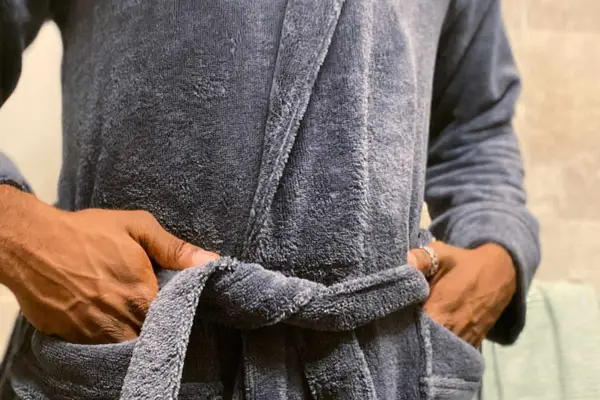 A person ties the belt on the Cariloha Bamboo Bath Robe