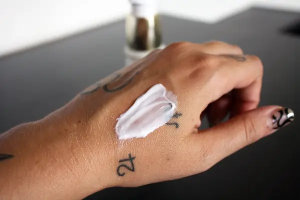 A person dispensing SkinCeuticals Micro-Exfoliating Scrub Smoothing Polish on the back of hand