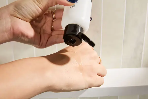 A person dispensing The Inkey List PHA Gentle Exfoliating Toner on the back of their hand
