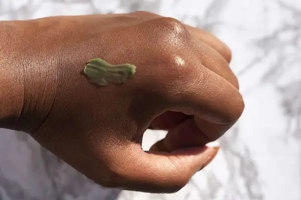 Close-up of Kate Somerville ExfoliKate Intensive Exfoliating Treatment dollop on back of hand