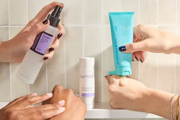 Three pairs of hands testing face exfoliators from Cosrx, Glytone, and Tula