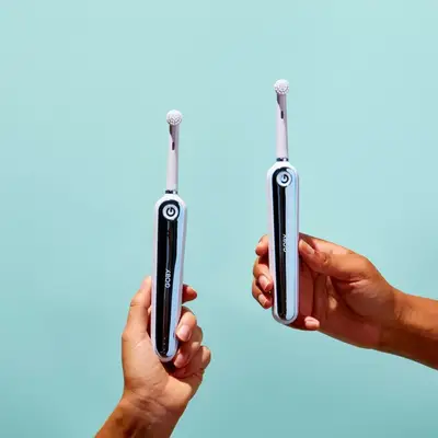 Goby toothbrush being held by a set of hands