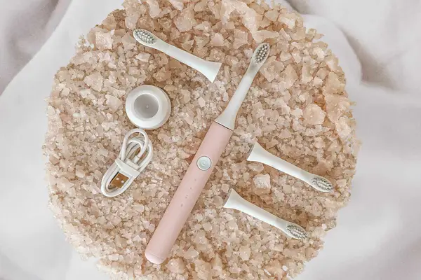 Electric toothbrush surrounded by different replacement parts