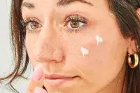 A person applies Neutrogena Rapid Tone Repair Retinol + Vitamin C Dark Spot Corrector