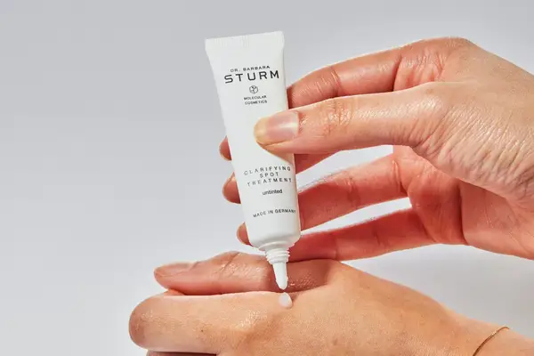 A hand squeezing out a small sample of Dr. Barbara Sturm Untinted Clarifying Spot Treatment