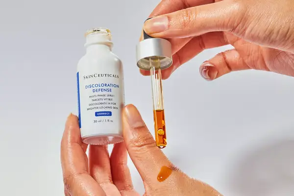 Person squeezing Skinceuticals Discoloration Defense onto their hand