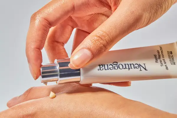 A person applies Neutrogena Rapid Tone Repair Retinol + Vitamin C Dark Spot Corrector