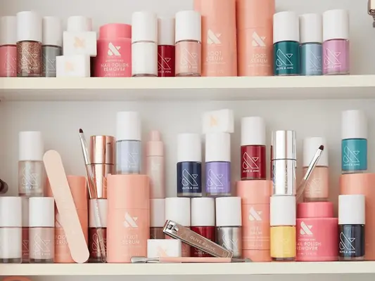 Olive & June at-home manicure tools and nail polishes on three shelves.