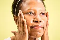 A person rubbing Sulwhasoo Gentle Cleansing Oil onto their face