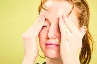 A person rubbing their eyebrows with Dermalogica Precleanse Cleansing Oil