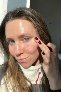 A person using their finger to apply La Roche-Posay Matte Toleriane Double Repair Moisturizer to their cheek
