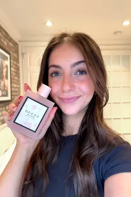 A person holding The Maker Lover Eau de Parfum perfume bottles in two separate poses