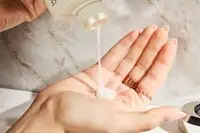 A person pouring Kérastase Densifique Bain Densité Shampoo into their hand